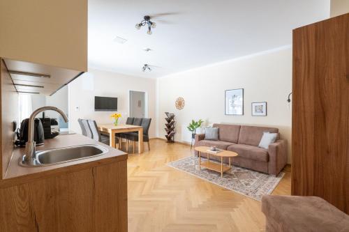 a kitchen and living room with a couch and a table at Vienna Stay Apartments Schönbrunn in Vienna