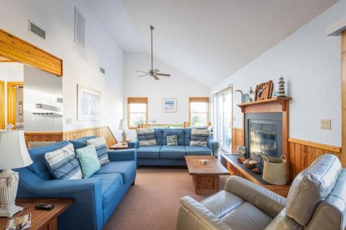 a living room with blue couches and a fireplace at Private Pool Spa & Spacious Deck in Corolla