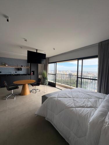 a bedroom with a large bed and a large window at ID Vida Urbana Studio Floresta in Goiânia