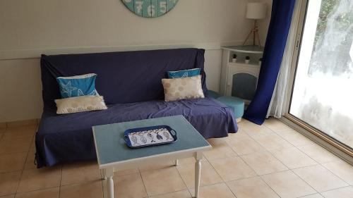 un salon avec un canapé violet et une table dans l'établissement Vacation home in a wooded park, à Saint-Jean-de-Monts