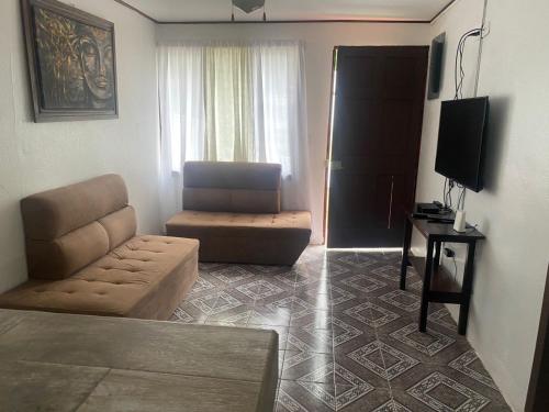 a living room with a couch and a chair at Villas manuel antonio in Quepos