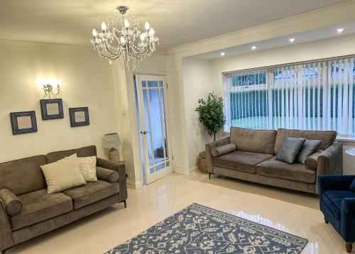 a living room with two couches and a chandelier at Comfy NEC, Birmingham Airport Stay, Free Parking in Birmingham