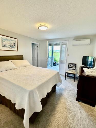 a bedroom with a large bed and a television at Mountain Ash Country Manor and Spa in Creemore
