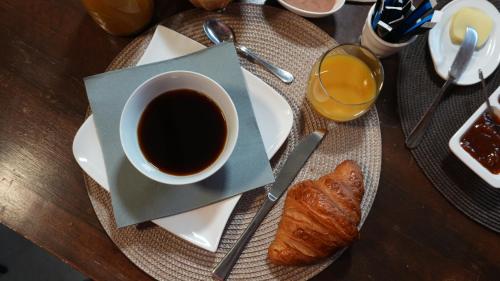 una taza de café y un cruasán sobre una mesa en Écolodge Les Sentiers du Lac - Domaine de la Gaïa, en Sorèze