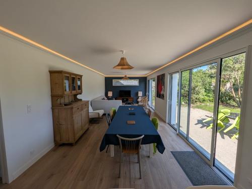 une salle à manger avec une table et des chaises bleues dans l'établissement Maison familiale design proche plage draps fournis, à Étel