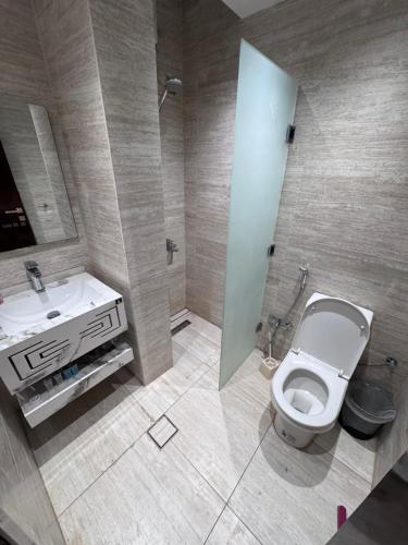 a bathroom with a white toilet and a sink at Madain Al Baraka Suites أجنحة مدائن البركة in Medina