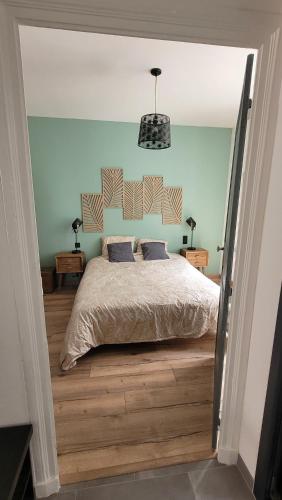 - une chambre avec un lit et une lampe pendant dans l'établissement Maison élégante entre Ré et Marais, à Marans