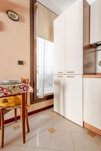 a kitchen with a table and a refrigerator at Live the History- A due passi dal Castello in Ferrara