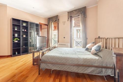 a bedroom with a bed and a television in it at Live the History- A due passi dal Castello in Ferrara