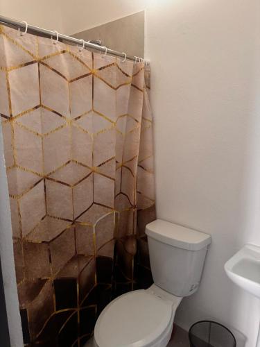 a bathroom with a toilet and a shower curtain at Blue Beach 2 min to Miramar Beach in Ciudad Madero