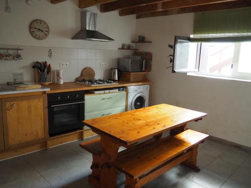 - une cuisine avec une table en bois et une cuisinière dans l'établissement Gîte Le petit Bonheur dans la vallée du Tarn, à Ambialet