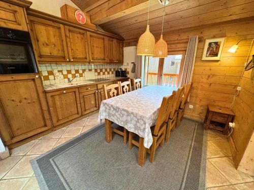 une cuisine avec une table et quelques placards en bois dans l'établissement Appartement Confort+ avec Balcon et Parking - 3 Chambres, 6 pers, WiFi - Les Menuires - FR-1-452-315, à Praranger