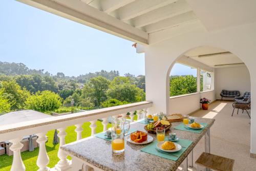 a table with food and drinks on a balcony at Calejo House – Pool & Sports & Grill Retreat in Nogueira