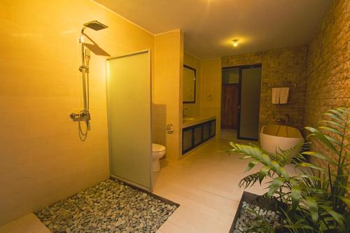 a bathroom with a shower and a toilet and a sink at Ubud Lestari Villa in Ubud