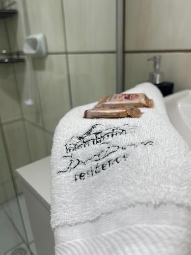 a white towel with writing on it in a bathroom at Apartamento no Costa e silva in Joinville