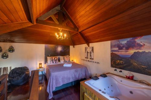 a bedroom with a bed and a bath tub at Recanto Lira 1 e 3 in Monte Verde