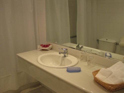 a bathroom counter with a sink and a mirror at Apartamentos Maritimo Suites-Solo Adultos in O Grove