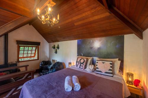 a bedroom with a bed with slippers on it at Recanto Lira 1 e 3 in Monte Verde