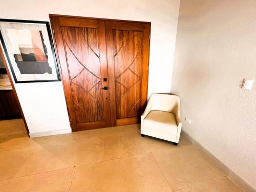 a chair sitting in front of a wooden door at Casa de Lujo con Piscina y Vistas Panorámicas Oro Monte, Naranjo in Naranjo
