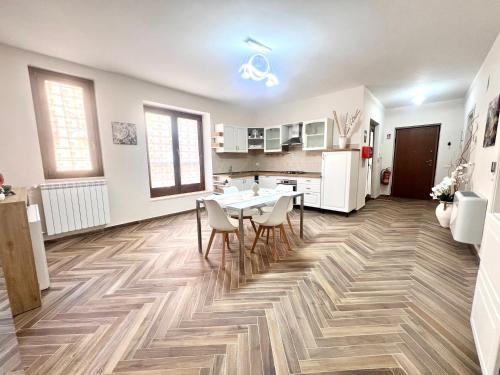 a kitchen with a table and chairs on a wooden floor at La Casa di Nina in Castelnuovo Cilento