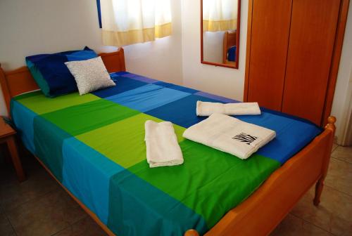 a bed with colorful sheets and towels on it at Georgia Apartments in Paphos City
