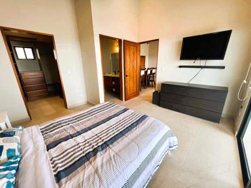 a bedroom with a bed and a flat screen tv at Casa de Lujo con Piscina y Vistas Panorámicas Oro Monte, Naranjo in Naranjo