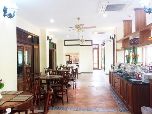 a dining room with wooden tables and chairs at i Boutique Hotel in Pluak Daeng