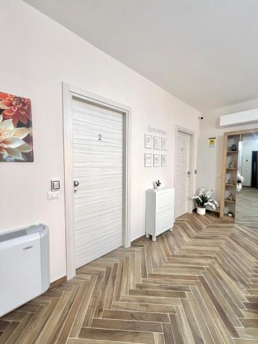a hallway with a white door and wooden floors at La Casa di Nina in Castelnuovo Cilento