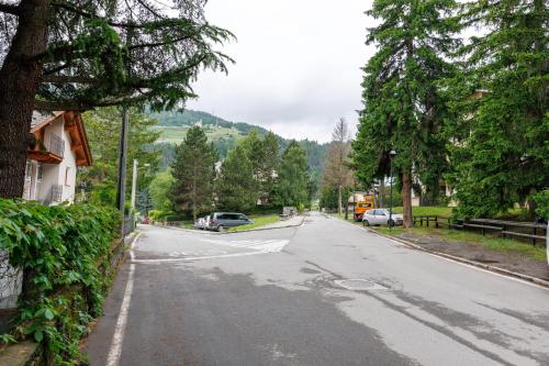 an empty street with cars parked on the road at Accogliente appartamento Erica, Bormio in Bormio