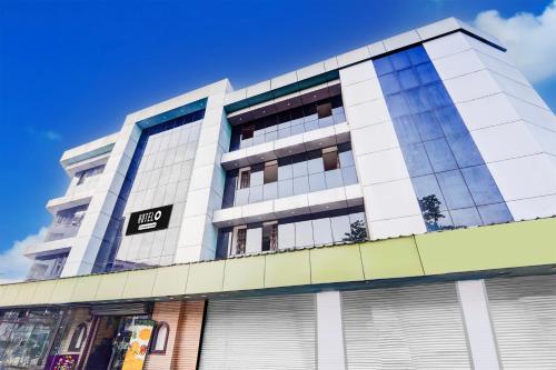 a tall white building with a sign on it at Hotel O DH Road Ernakulam in Cochin