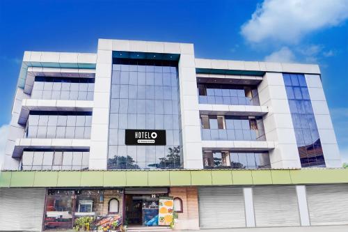 a white building with a black sign on it at Hotel O DH Road Ernakulam in Cochin