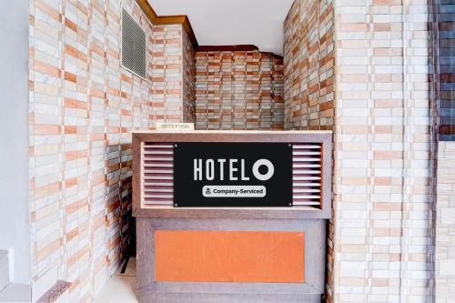 a hotel sign on the side of a brick wall at Hotel O DH Road Ernakulam in Cochin