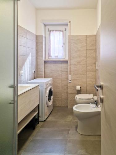 a bathroom with a washing machine and a washer at Nido nel verde in Segrate