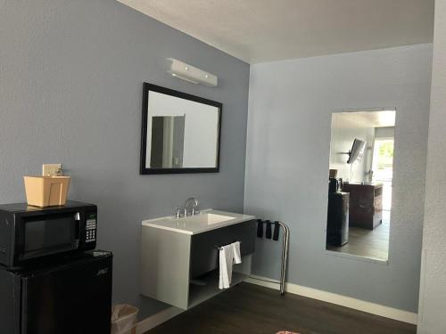 a bathroom with a sink and a microwave at Oasis Inn and Suites in Fallon