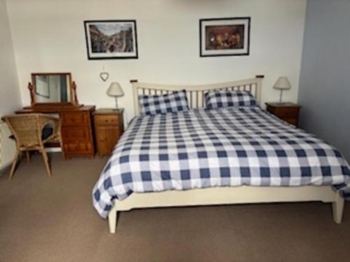 Un dormitorio con una cama, un escritorio y un espejo. en PetFriendly-Beachfront-SunsetFacingSunPorch-Garden, en Portmahomack