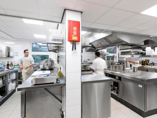 two men in a kitchen preparing food in a kitchen at Valuas in Venlo