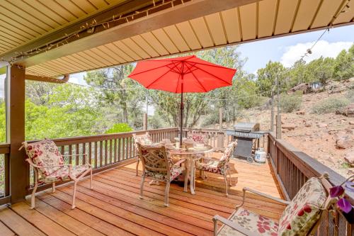 a wooden deck with a table and chairs and an umbrella at Mtn and Golf Course Views Payson Retreat! in Payson