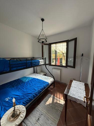 a bedroom with two bunk beds and a table at Casolare De Ranieri - appartamento in villa bifamiliare a 500m dal mare in Marina di Massa