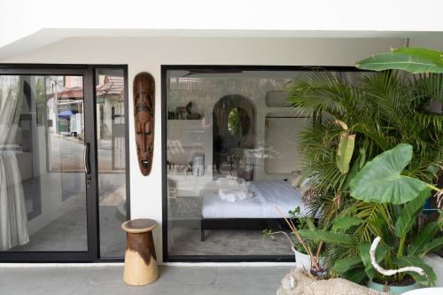 een kamer met een bed bij het raam met planten bij Rwanda Naziza - Private Villa in the Old Town City - PRIME LOCATION I Daily Housekeeping in Chiang Mai