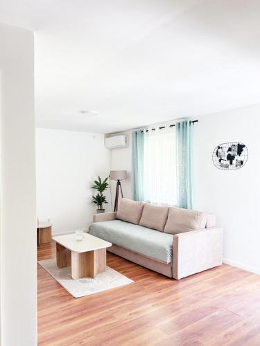 a white living room with a couch and a table at House9 in Kotor