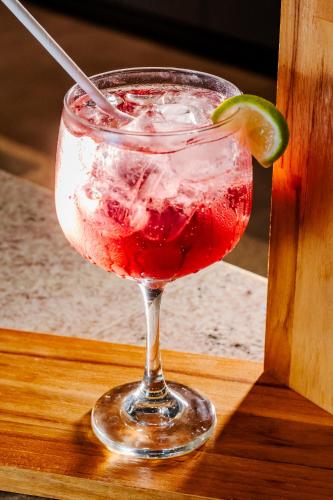 a drink in a glass with a lime on a table at Ibis Styles Macaé in Macaé