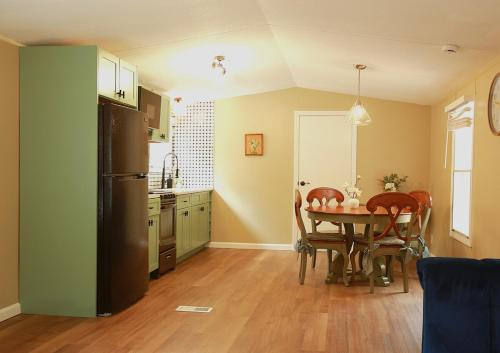 une cuisine avec une table avec des chaises et un réfrigérateur dans l'établissement Riverfront Cottage with Sauna & Hot Tub, à Liberty
