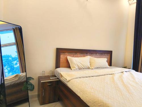 a bedroom with a bed with a dresser and a mirror at The Hills & Waves in Rishīkesh