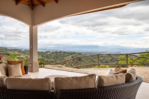 a patio with wicker furniture and a view of the mountains at Casa de Lujo con Piscina y Vistas Panorámicas Oro Monte, Naranjo in Naranjo
