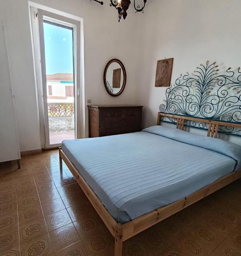 a bedroom with a large bed with a mirror and a window at Casa da Oscar in Marcelli