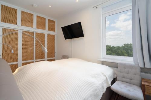 a white bedroom with a bed and a window at Panoramic App C09-8 in Sierksdorf