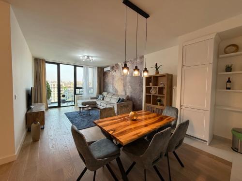 a living room with a wooden table and chairs at BelgradeWATERFRONT - Apartments in Sajmište
