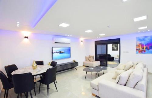 a living room with a white couch and a table at וילת לוויס בגליל in Zar‘it