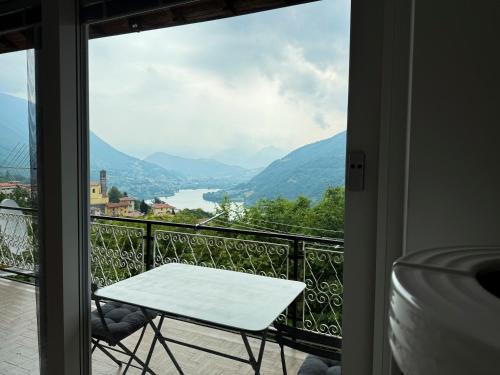 a table and chairs on a balcony with a view at Casa Lagò Lagò Panoramic Apartment in Ranzanico
