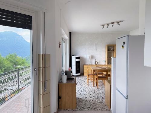 a kitchen and dining room with a view of a balcony at Casa Lagò Lagò Panoramic Apartment in Ranzanico